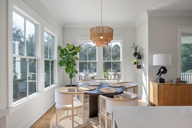 dining space with light wood finished floors, baseboards, and crown molding