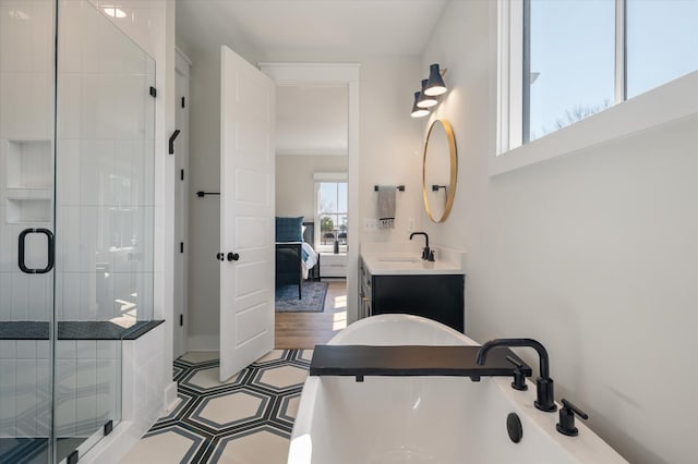 ensuite bathroom with a freestanding tub, a shower stall, vanity, and ensuite bathroom