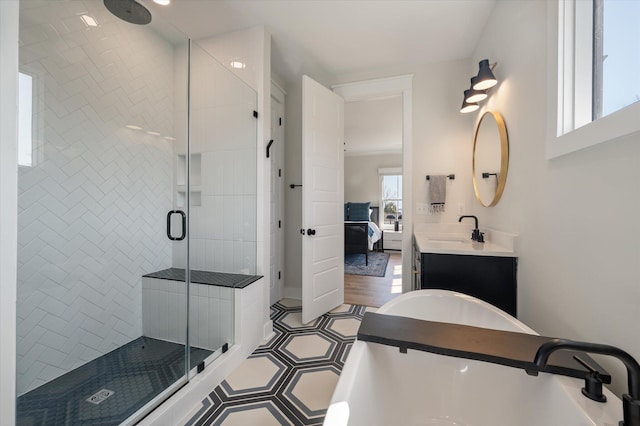 ensuite bathroom featuring a soaking tub, ensuite bath, vanity, and a shower stall