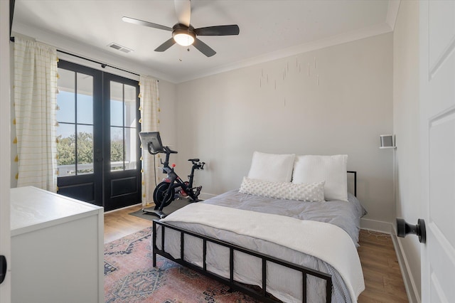 bedroom featuring baseboards, wood finished floors, and crown molding