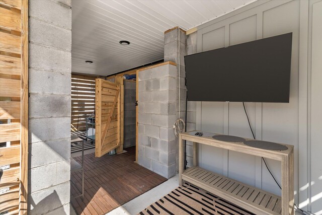 interior space with wood ceiling and concrete block wall