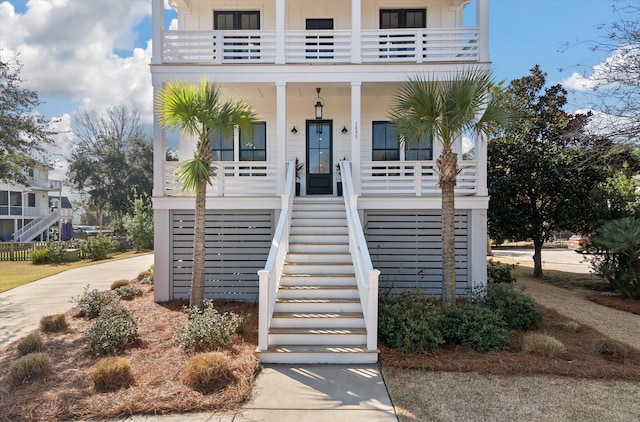 coastal inspired home with stairs and a porch