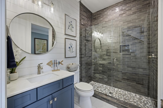 bathroom featuring toilet, a stall shower, vanity, and tile patterned floors
