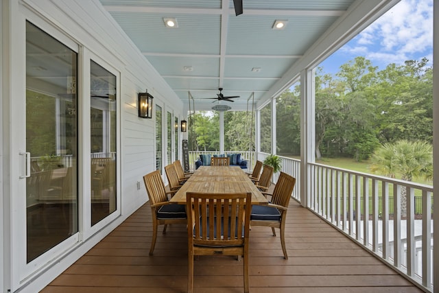sunroom / solarium featuring ceiling fan, outdoor dining space, and beam ceiling