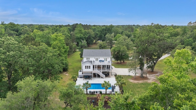 view from above of property featuring a forest and a pool
