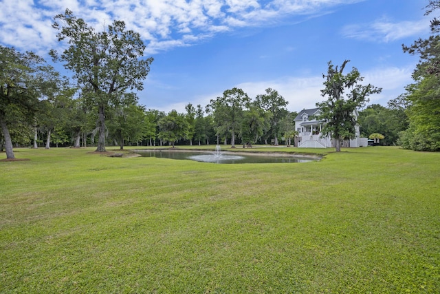 view of home's community with a water view and a yard