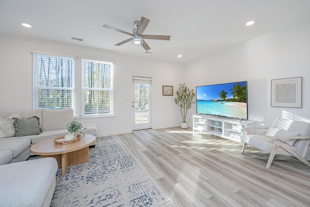 living room featuring light wood-type flooring and ceiling fan