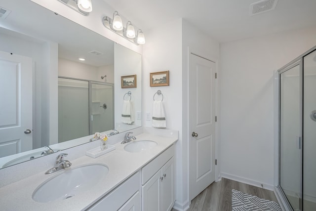 bathroom with vanity, a shower with door, and hardwood / wood-style floors