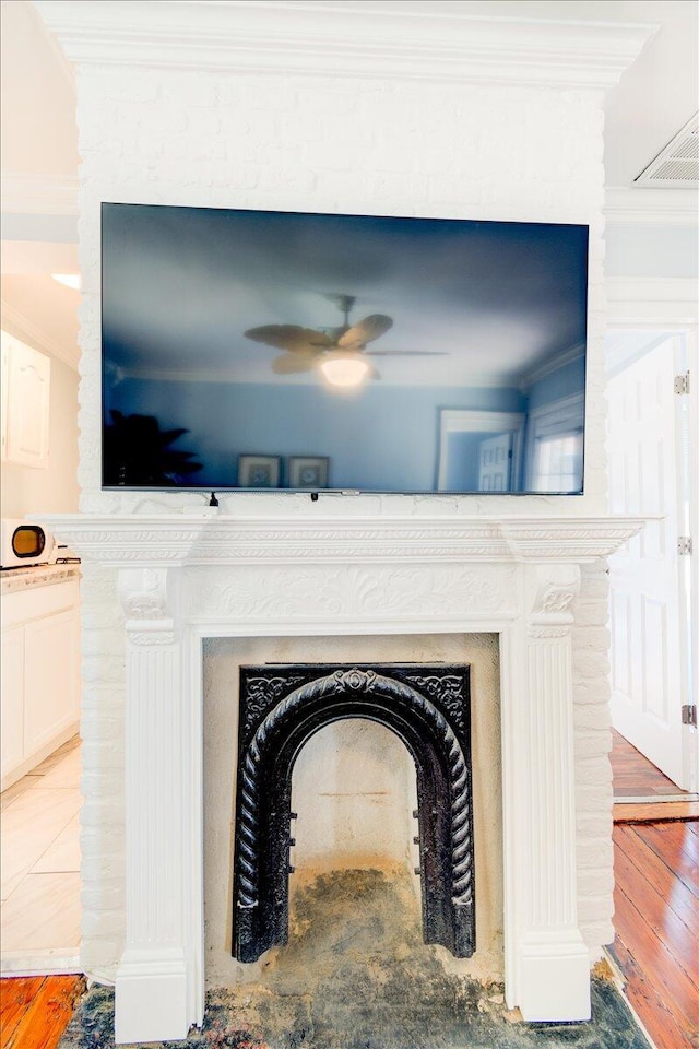 room details with hardwood / wood-style floors, ceiling fan, and crown molding