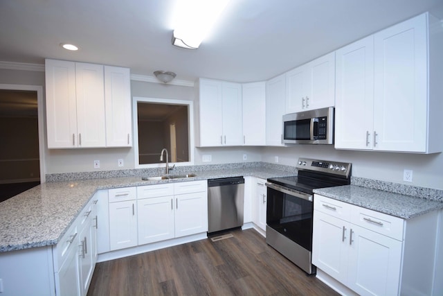 kitchen with dark wood-type flooring, white cabinets, sink, appliances with stainless steel finishes, and light stone counters