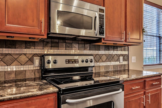 kitchen with backsplash, dark stone counters, and stainless steel appliances