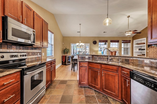 kitchen with sink, pendant lighting, vaulted ceiling, and stainless steel appliances