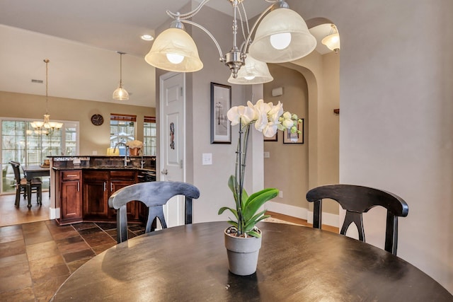 dining space featuring sink and an inviting chandelier