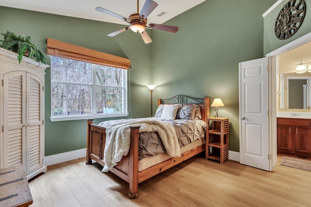 bedroom with lofted ceiling, light wood-type flooring, ensuite bath, and ceiling fan