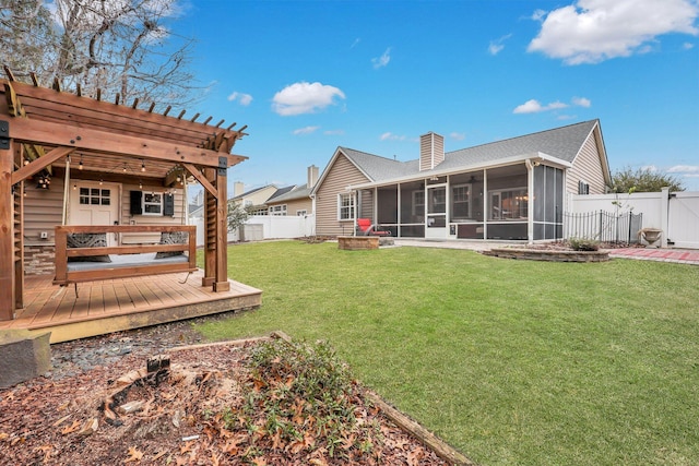 back of property with a lawn, a sunroom, a wooden deck, and a pergola