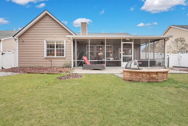 back of property with a patio, a lawn, and a sunroom