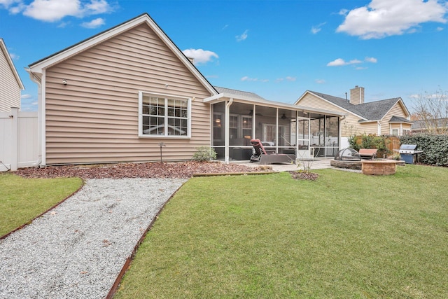 back of property featuring a patio area, a sunroom, a fire pit, and a lawn