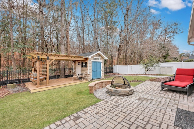 view of patio / terrace featuring a deck, an outdoor fire pit, and a shed