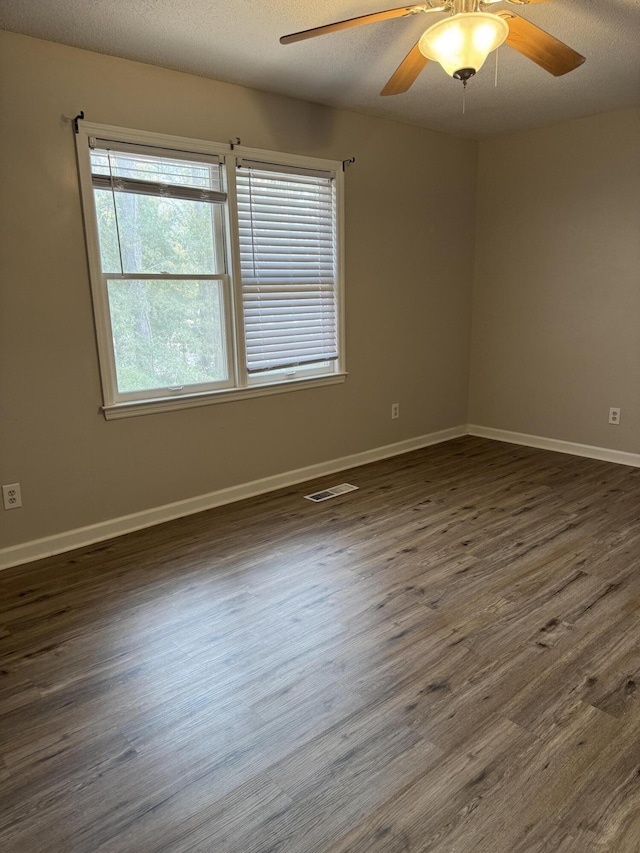 spare room with ceiling fan, dark hardwood / wood-style flooring, and a textured ceiling