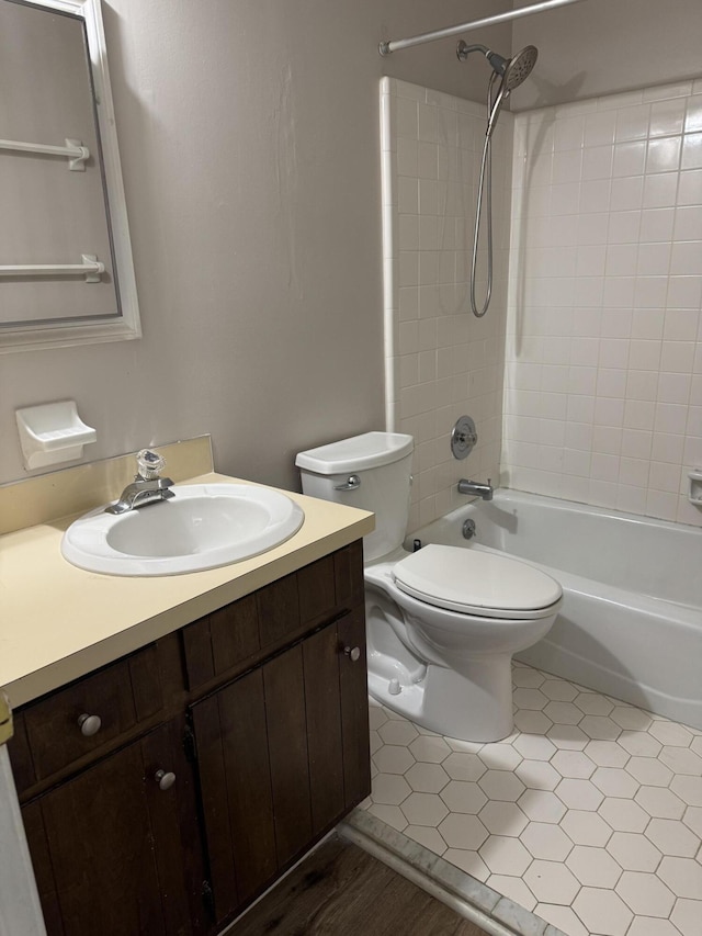 full bathroom with hardwood / wood-style flooring, vanity, toilet, and tiled shower / bath