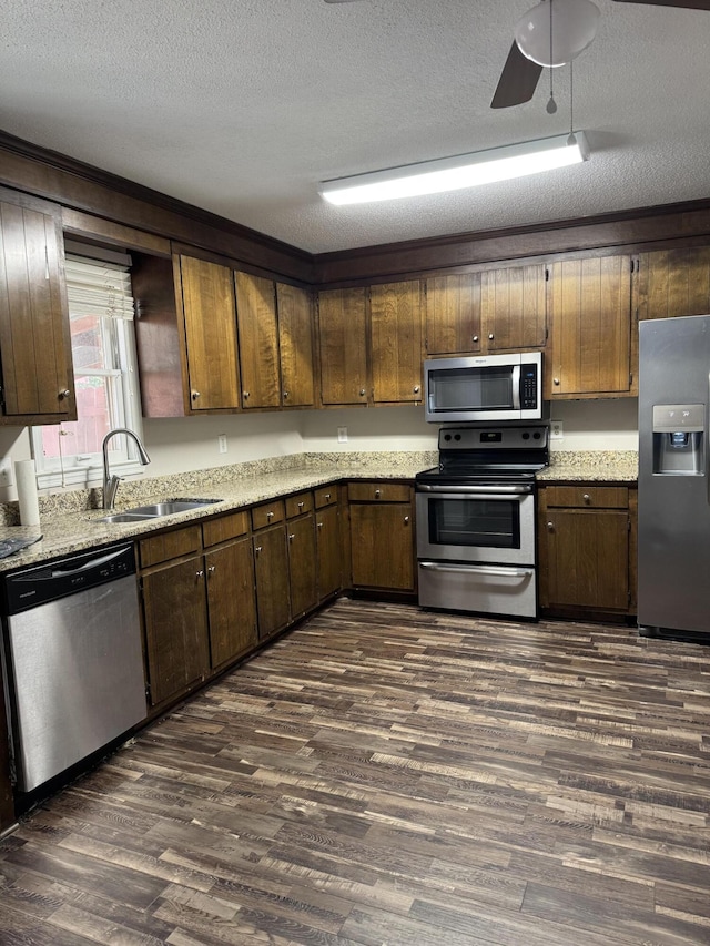 kitchen with a textured ceiling, sink, dark hardwood / wood-style floors, and appliances with stainless steel finishes