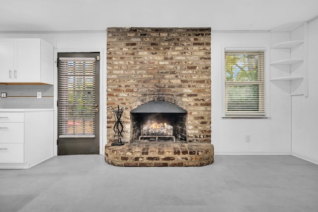 living room with baseboards and a brick fireplace