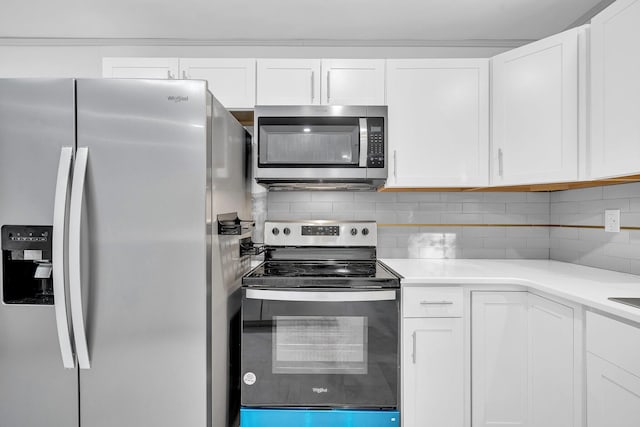 kitchen with stainless steel appliances, light countertops, backsplash, and white cabinetry