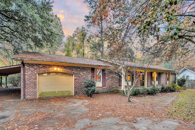 ranch-style house with an attached garage, brick siding, aphalt driveway, and covered porch