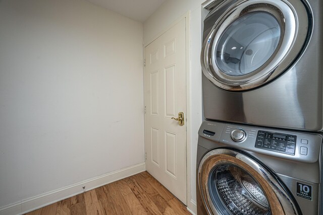 3701 Docksite Rd Unit 220, Edisto Island, SC 29438 - laundry room featuring stacked washing machine and dryer, light wood-style floors, and baseboards
