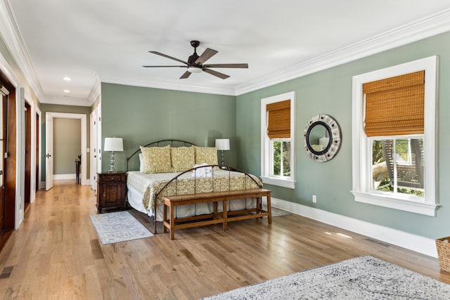 bedroom featuring crown molding, light hardwood / wood-style floors, and ceiling fan