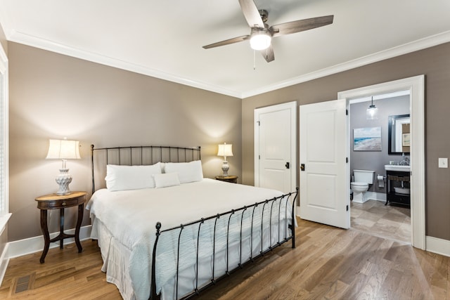 bedroom featuring light hardwood / wood-style floors, ceiling fan, crown molding, and ensuite bath