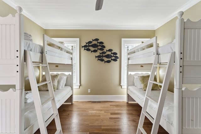 bedroom with ornamental molding, ceiling fan, dark hardwood / wood-style floors, and multiple windows