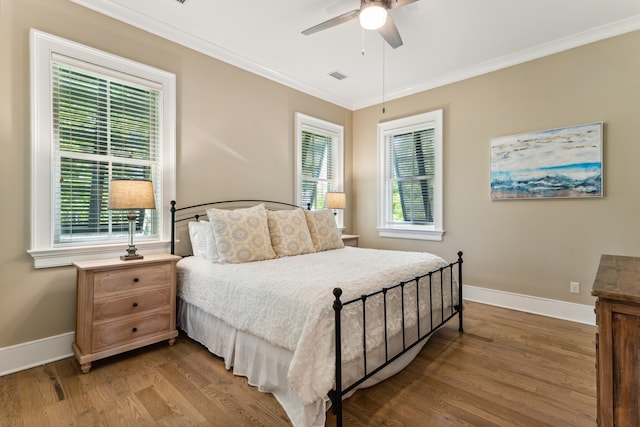 bedroom featuring ceiling fan, dark wood-type flooring, and ornamental molding