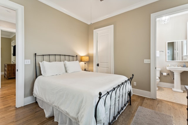 bedroom with ornamental molding, wood-type flooring, and ensuite bathroom