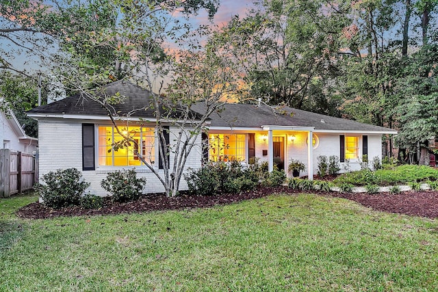 ranch-style home featuring a porch and a yard