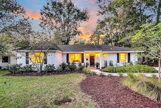 ranch-style home featuring a lawn