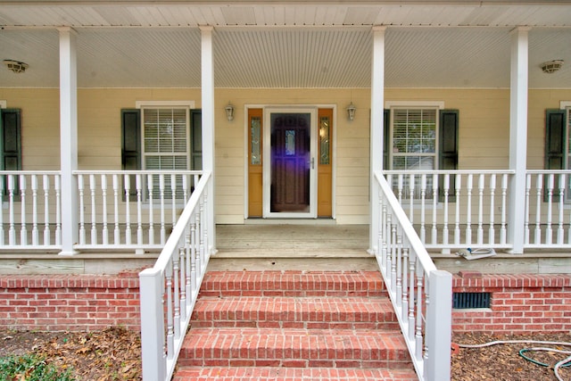 entrance to property featuring crawl space and covered porch