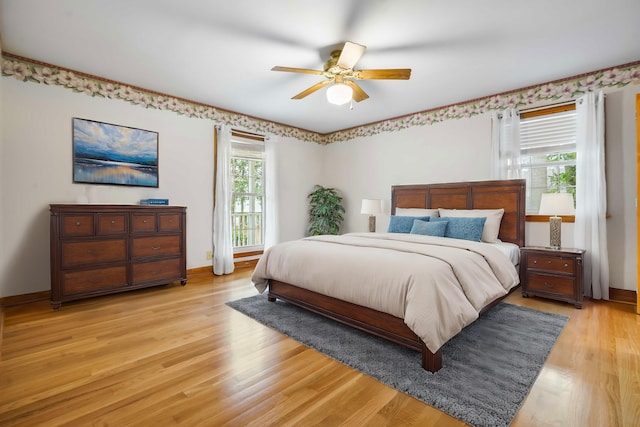 bedroom featuring light wood-style flooring, baseboards, and ceiling fan