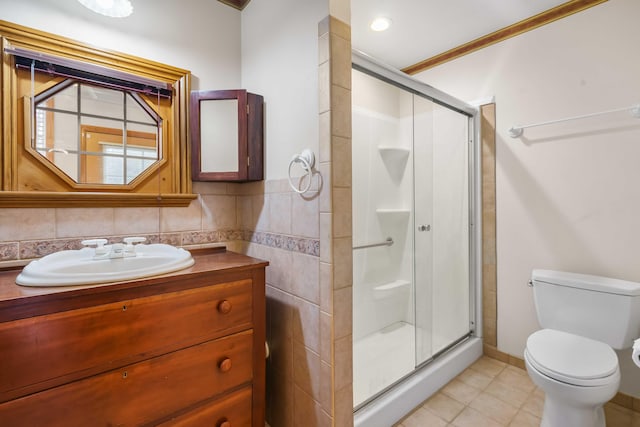 bathroom featuring vanity, a shower stall, toilet, and tile walls