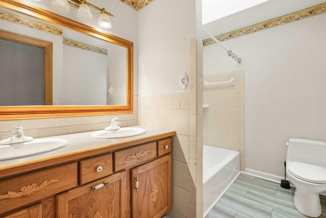 full bathroom featuring a sink, toilet, tile walls, and double vanity