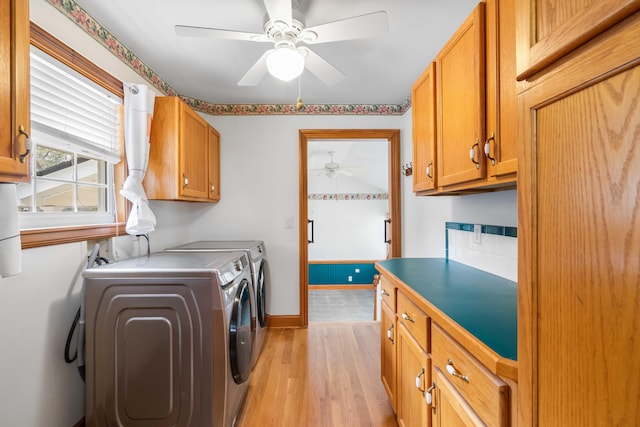 laundry area with light wood finished floors, baseboards, ceiling fan, cabinet space, and independent washer and dryer