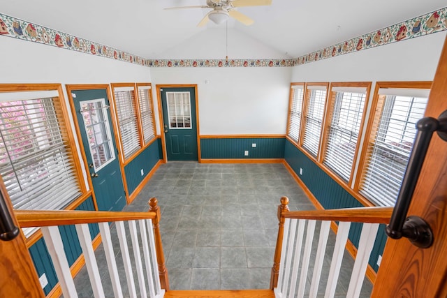 spare room featuring a wainscoted wall, ceiling fan, and lofted ceiling