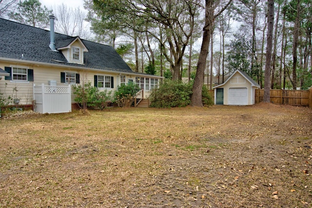 view of yard with an outbuilding, fence, and a garage