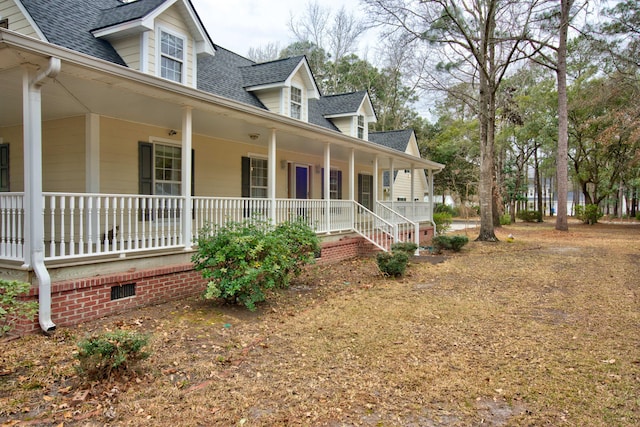 view of side of property with crawl space, covered porch, and roof with shingles