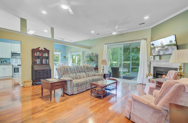 5406 E Crosland Ct, North Charleston, SC 29420 - living area featuring a ceiling fan, crown molding, light wood finished floors, a warm lit fireplace, and recessed lighting