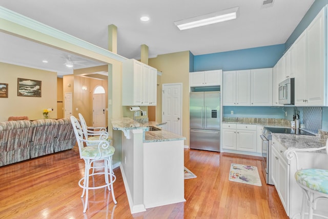 5406 E Crosland Ct, North Charleston, SC 29420 - kitchen featuring stainless steel appliances, a breakfast bar, a peninsula, white cabinets, and recessed lighting