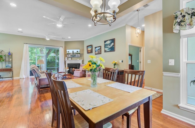 5406 E Crosland Ct, North Charleston, SC 29420 - dining room featuring a lit fireplace, crown molding, light wood-type flooring, a ceiling fan, and recessed lighting