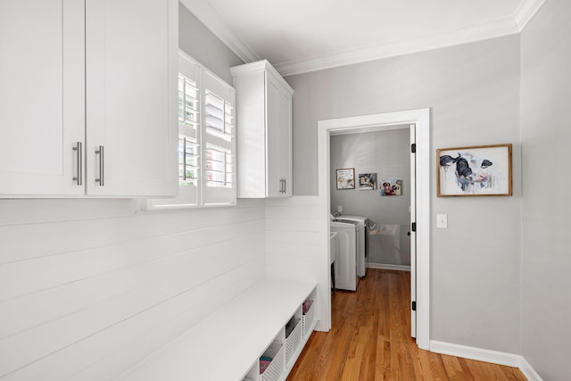 mudroom featuring crown molding, light wood-style flooring, baseboards, and washer and dryer