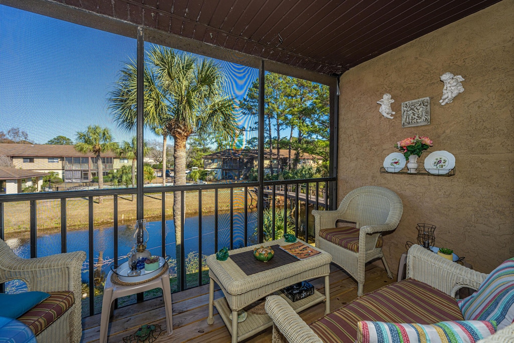 balcony with an outdoor living space and a water view