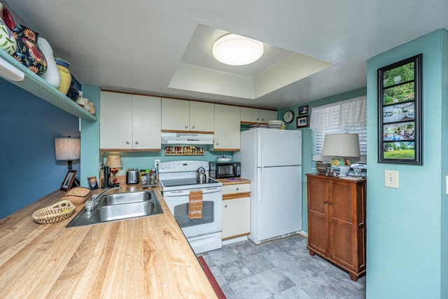 kitchen featuring white cabinets, a raised ceiling, white appliances, and sink